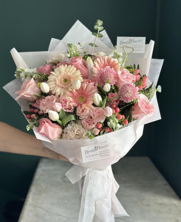 The Love Statement - mix bouquet, gerbers , tulips , roses , eucalyptus and more.  Handheld bouquet , you may request certain color wrap, no vase included. Call to request vase if needed.