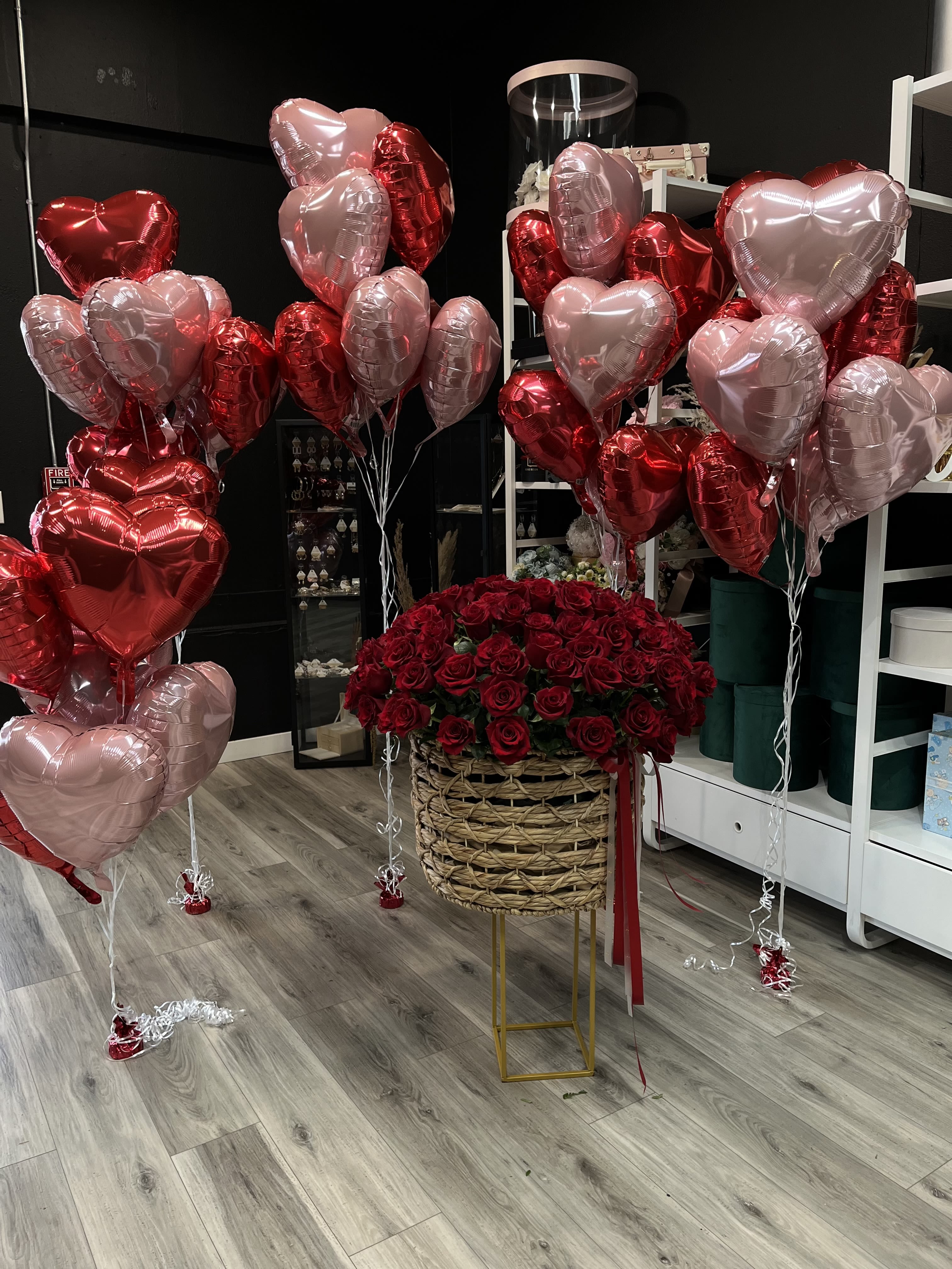 Red rose arrangement with pink and red heart balloons