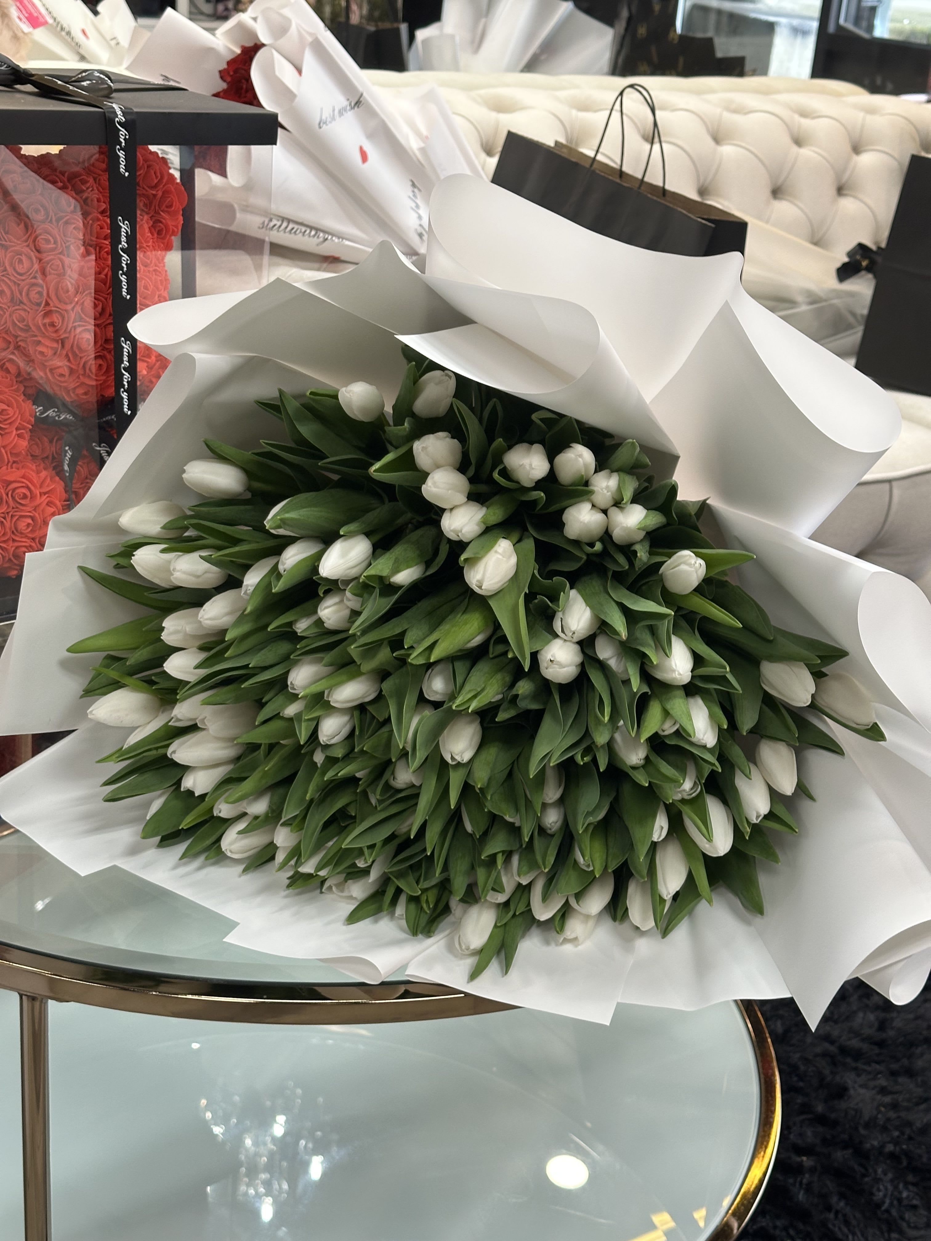 Century (100) of White tulips - This exquisite bouquet features 100 pure white tulips, meticulously arranged to create a grand and elegant display. A stunning symbol of purity and grace.»  