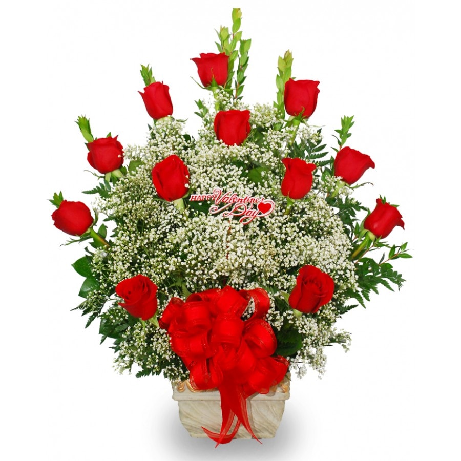 Red roses arranged in a white vase with a red bow
