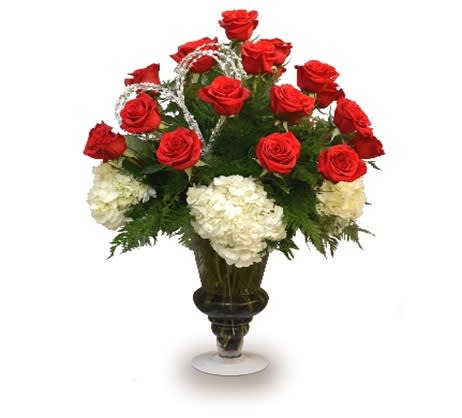 Red roses and white hydrangeas in a dark vase with silver ribbon accents