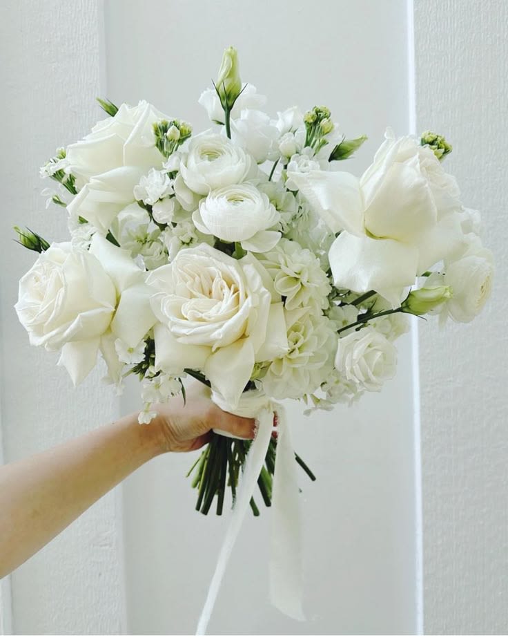 White rose bouquet with small white blooms and ribbon handle