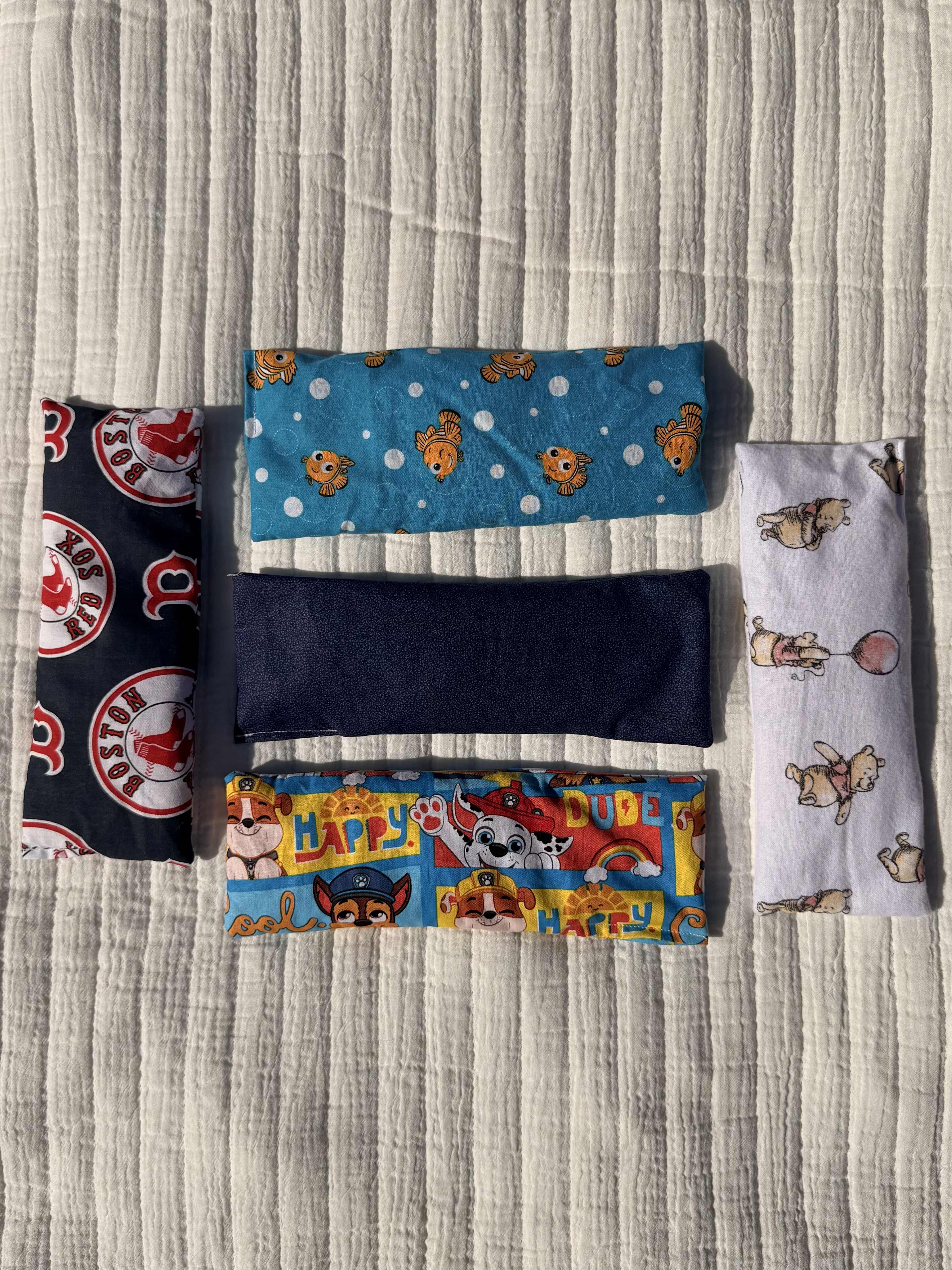 Rice and Lavender healing puches - Bright, playful rice and lavender healing pouches make a thoughtful comfort gift for someone who needs a little everyday calm. These fabric eye pillows work well as a get-well treat, a cozy birthday add-on for kids, or a small-gesture "thinking of you" present - the kind of comfort that helps the person you're sending it to relax, rest, or soothe tired eyes. Use warm (briefly heated) for comforting warmth or chilled in the freezer for gentle cooling relief; spot-clean the fabric surface as needed. Size and exact fill weight are matched across the five pieces so each pouch provides the same gentle, aromatic weight - perfect for helping someone feel seen and soothed in everyday moments.