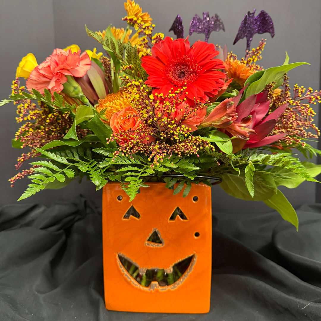 Autumn flower arrangement in an orange jack-o'-lantern container