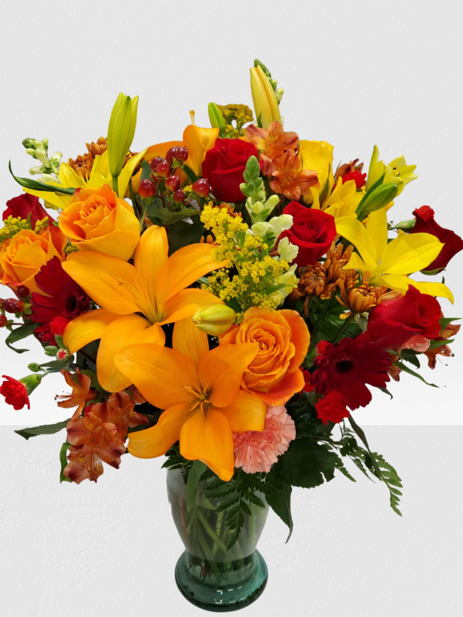 Mixed bouquet of orange and red flowers in a glass vase