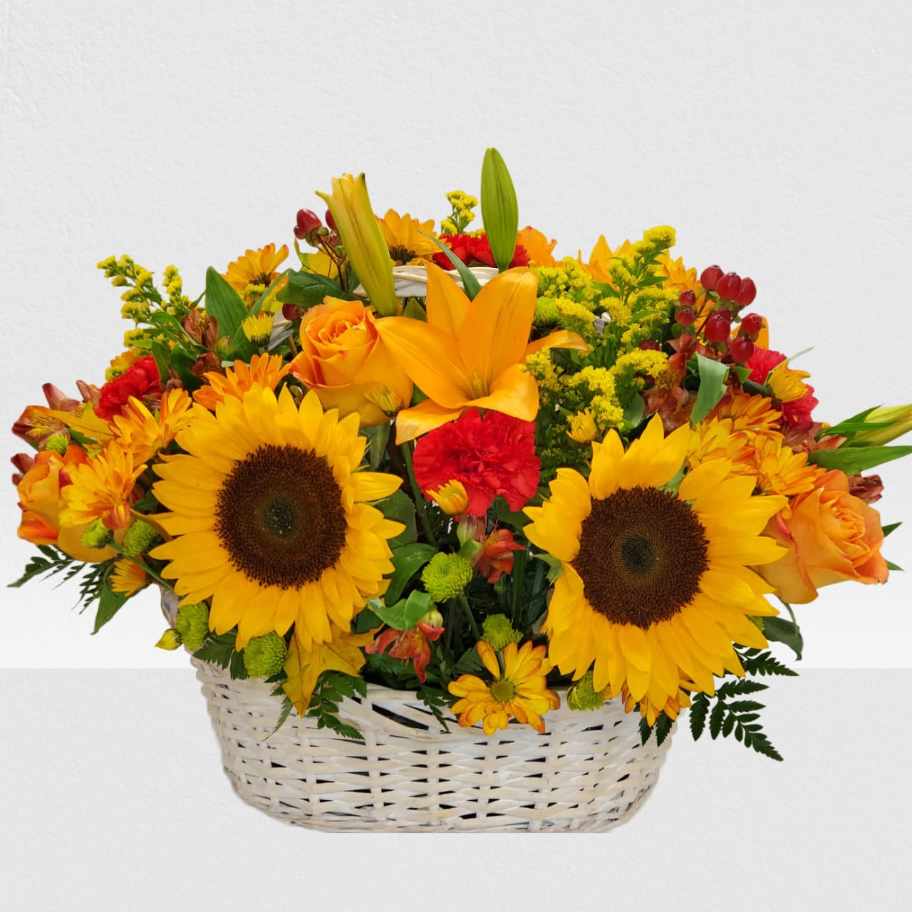 Basket arrangement with sunflowers, orange roses, and red flowers