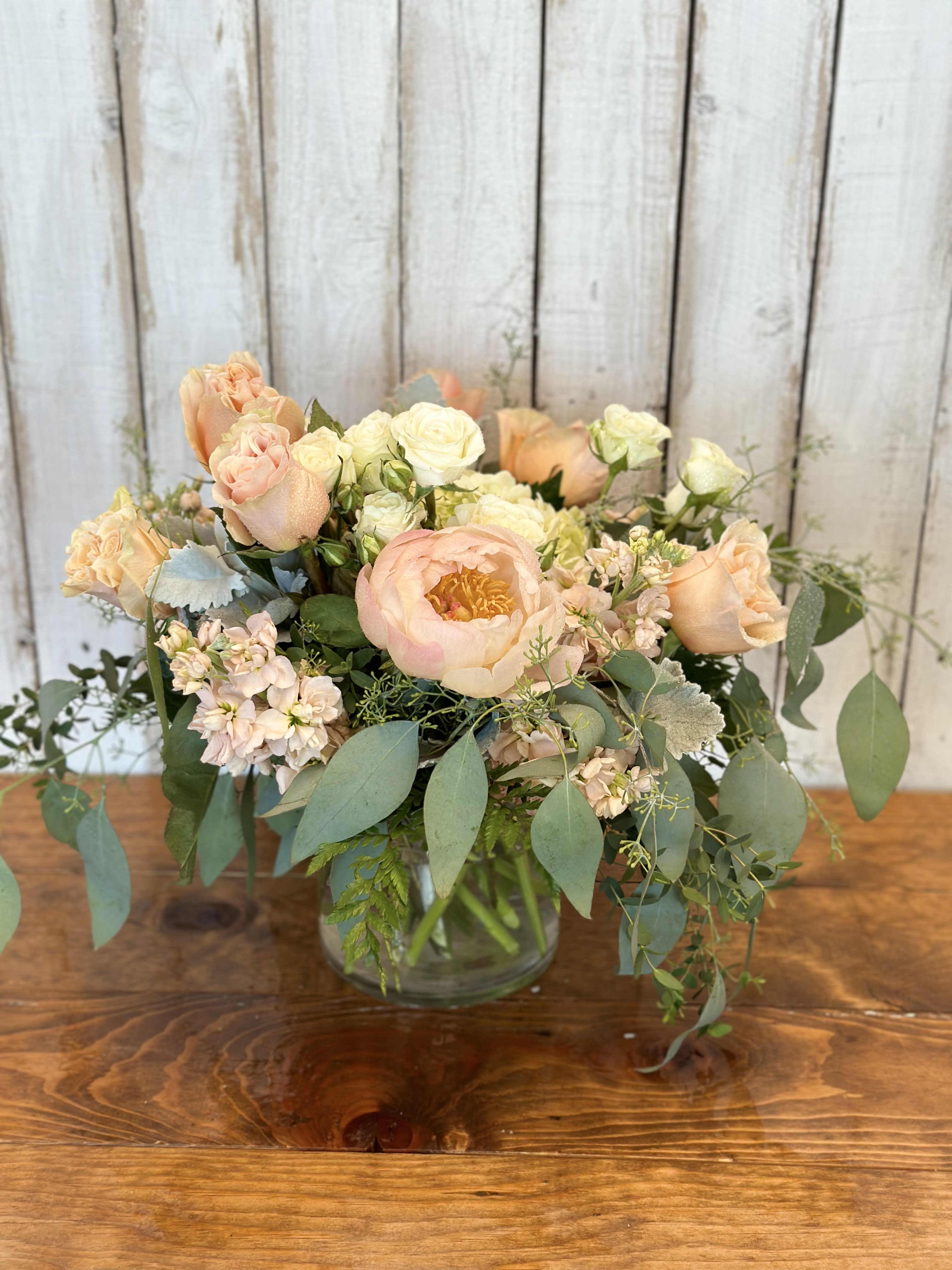 Peach and cream bouquet in a clear glass vase