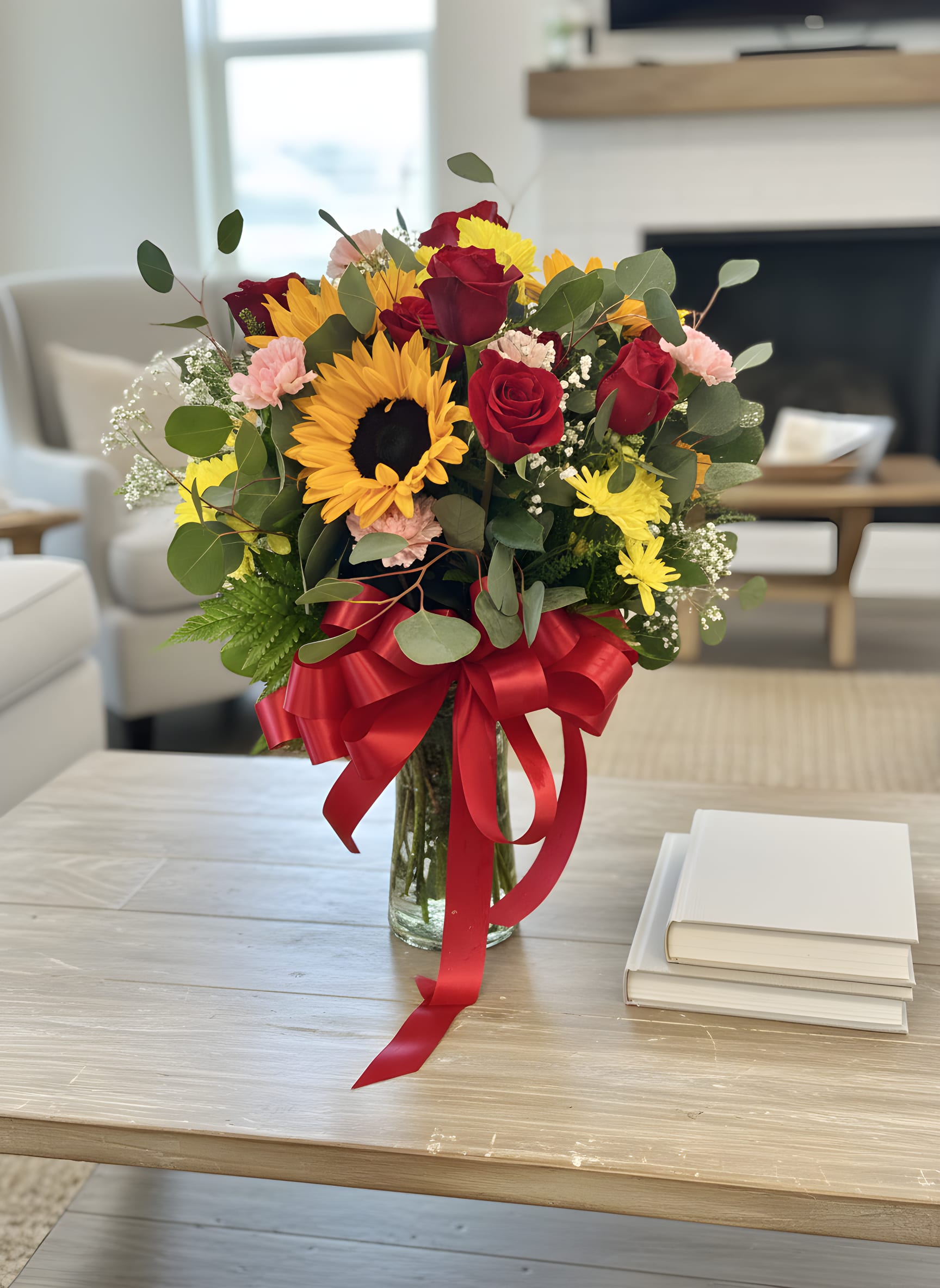 welcowelcome back to school™ Bouquet - Celebrate love, friendship, and life’s happiest moments with our Welcome back to school™ Bouquet. This stunning arrangement features radiant golden sunflowers, velvety red roses, soft pink carnations, cheerful yellow daisy mums, delicate baby’s breath, fresh eucalyptus, and lush seasonal greenery, all beautifully arranged in a clear glass vase and finished with a luxurious satin red bow.  The bold colors create the perfect balance of romance and sunshine, making this bouquet an unforgettable gift for birthdays, anniversaries, congratulations, or simply to brighten someone’s day.  Every arrangement is handcrafted by the floral designers at Tommy Austin Florist using premium, fresh flowers for exceptional beauty and long-lasting enjoyment. 