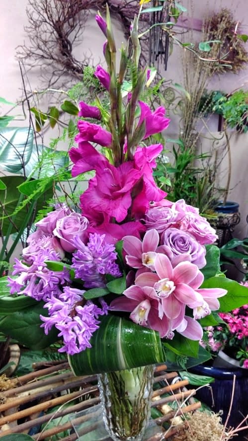Tall pink and lavender floral arrangement in a clear vase