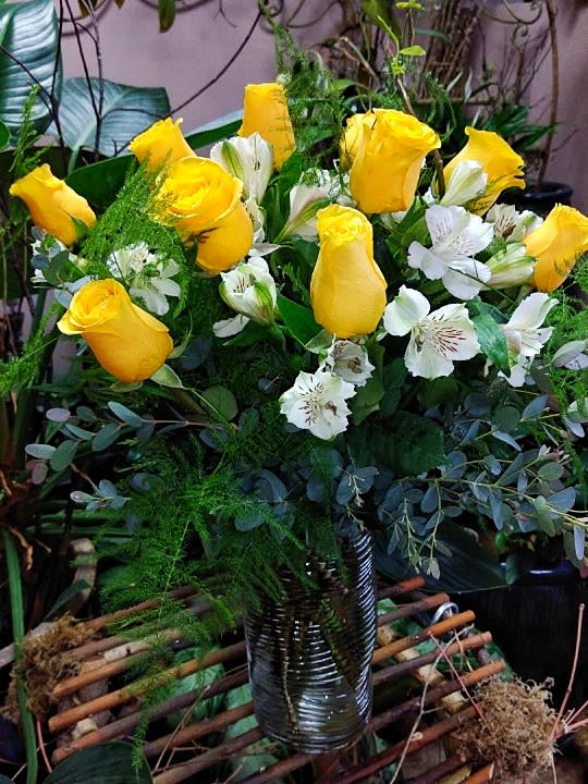 Yellow roses and white alstroemeria in a ribbed glass vase