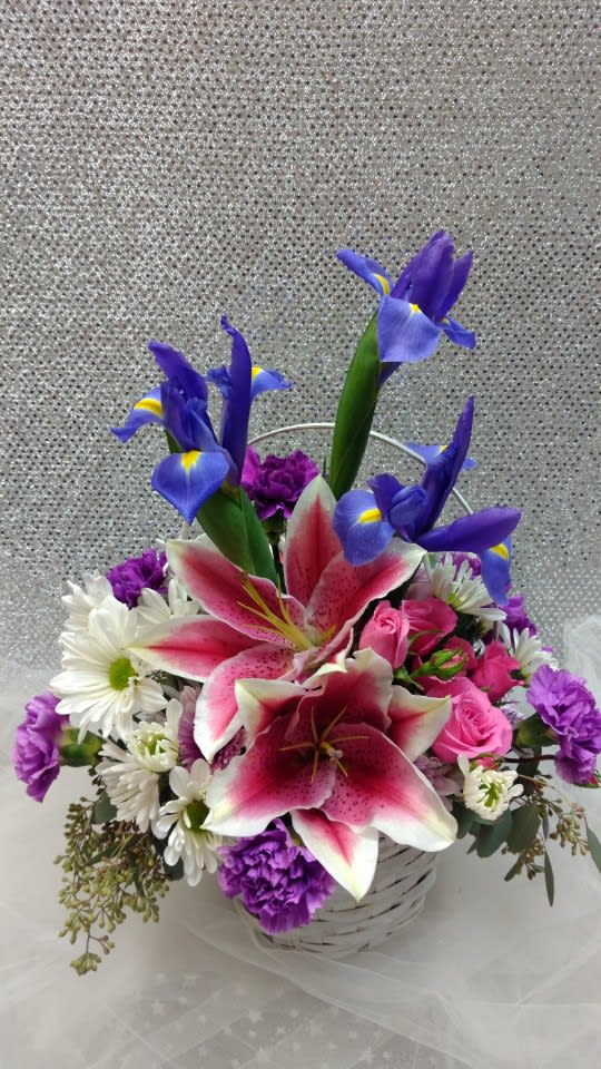 Basket arrangement with pink lilies, blue irises, and white daisies