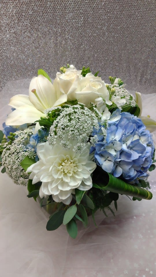 Bouquet of white roses, lilies, and blue hydrangea