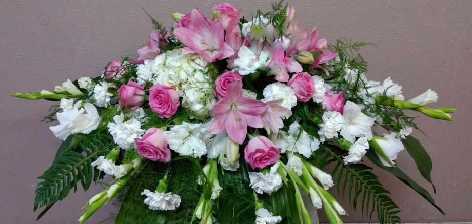 Pink and white floral spray with lilies, roses, and carnations