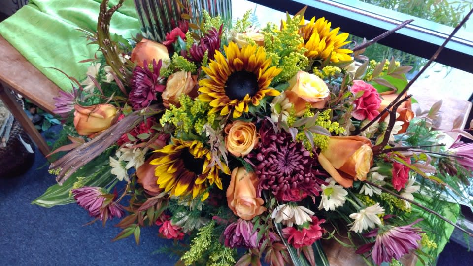 Mixed bouquet with sunflowers, roses, and chrysanthemums in warm autumn colors