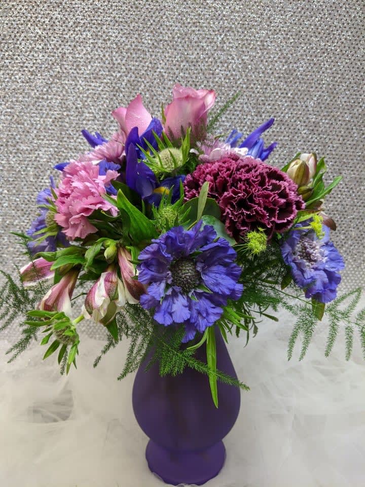Purple and pink mixed bouquet in a purple vase