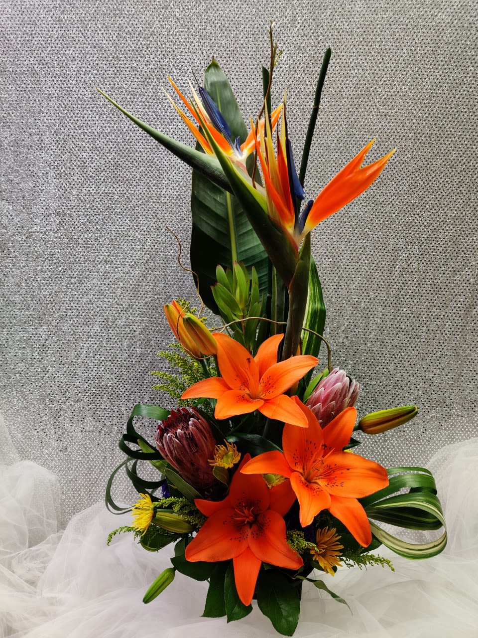 Tall tropical bouquet with orange lilies and bird of paradise