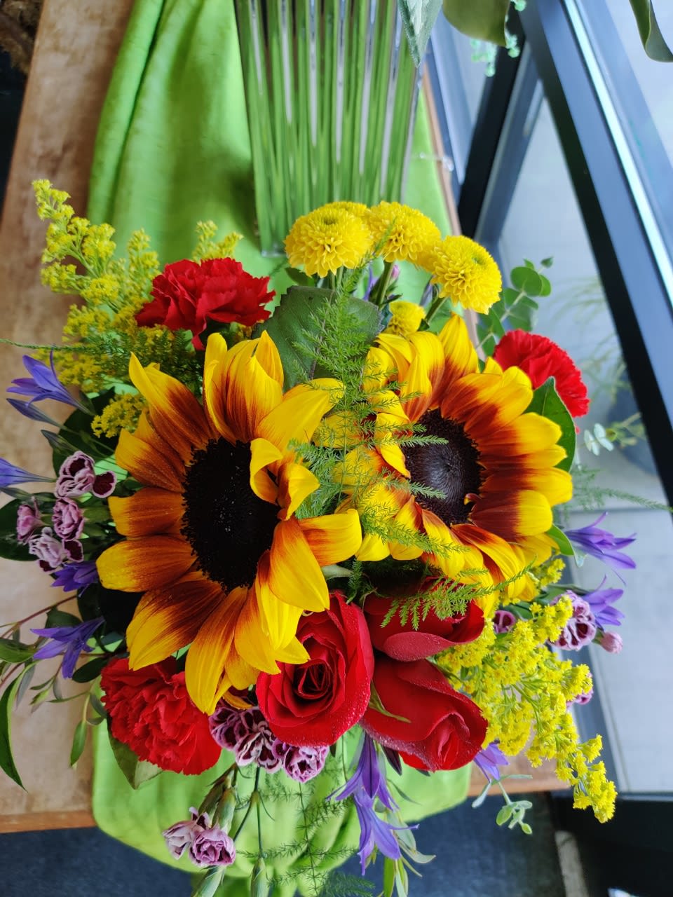Bouquet of sunflowers, red roses, and mixed accent flowers