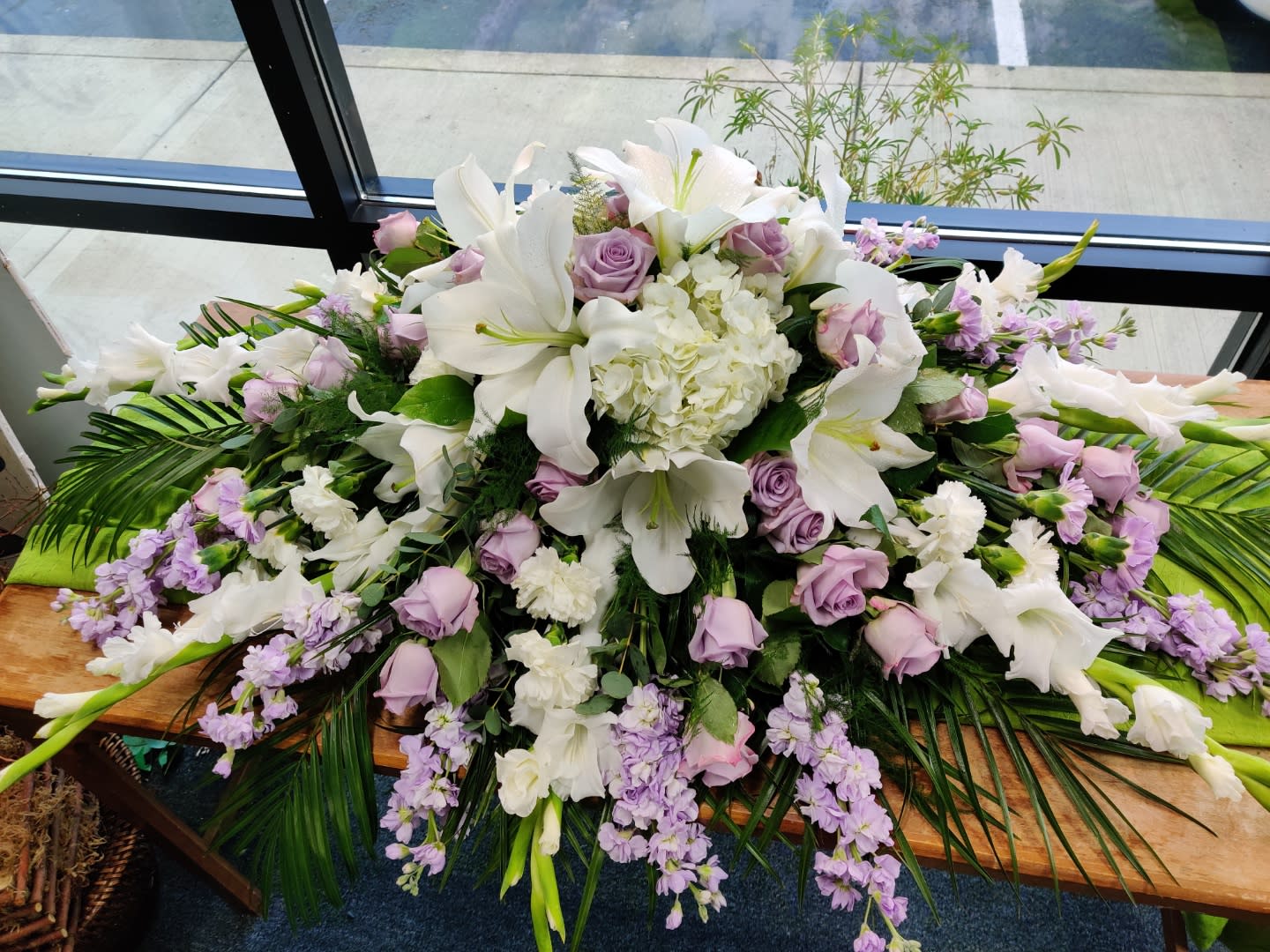 Large white and lavender floral arrangement with lilies and roses