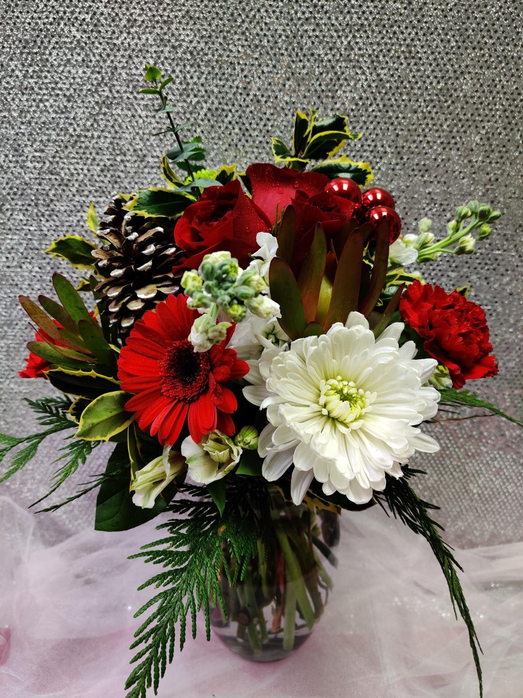 Red and white mixed flower arrangement in a glass vase