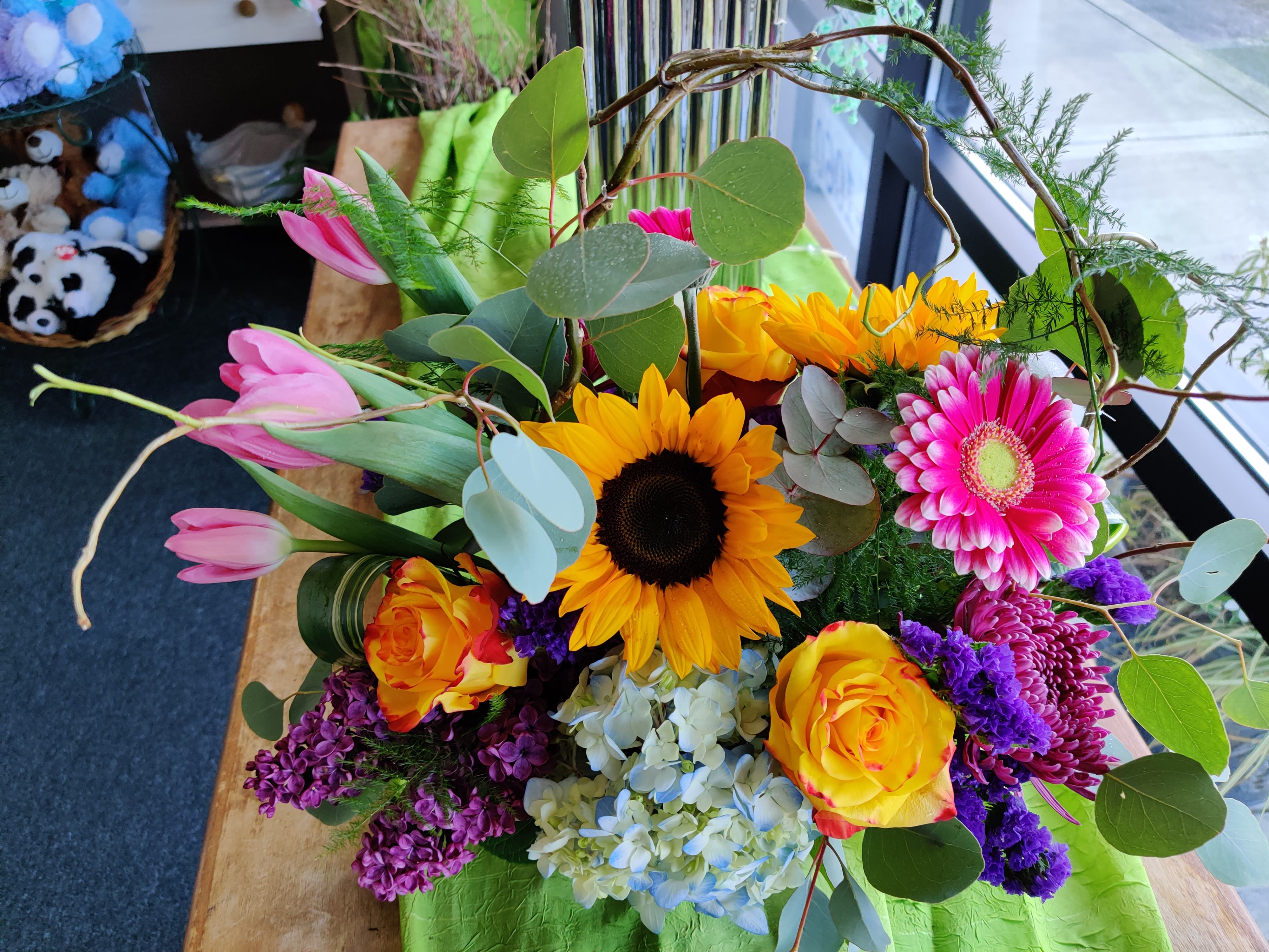 Mixed bouquet with sunflowers, pink tulips, roses, and a gerbera daisy