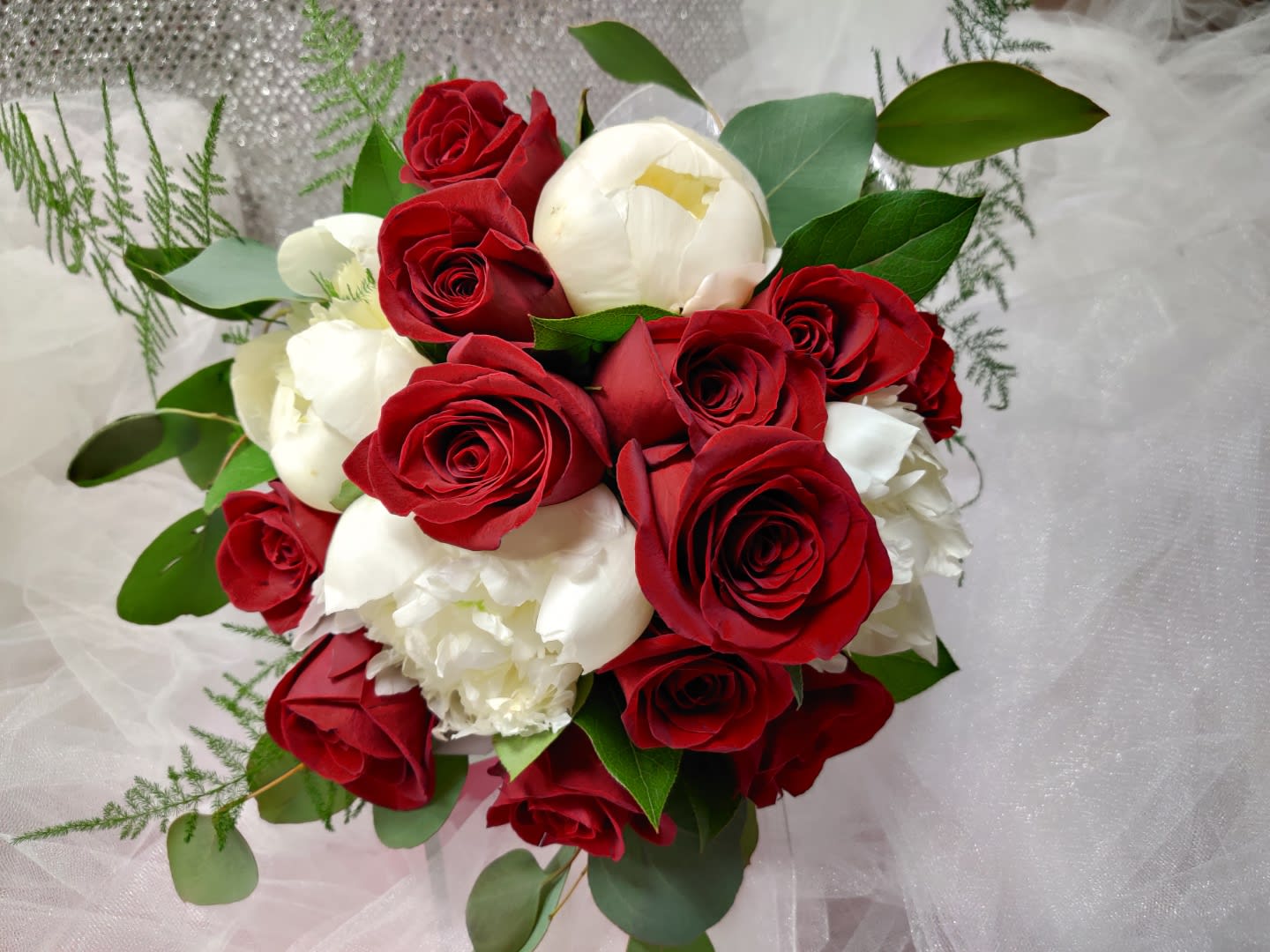 Bouquet of red and white roses with greenery