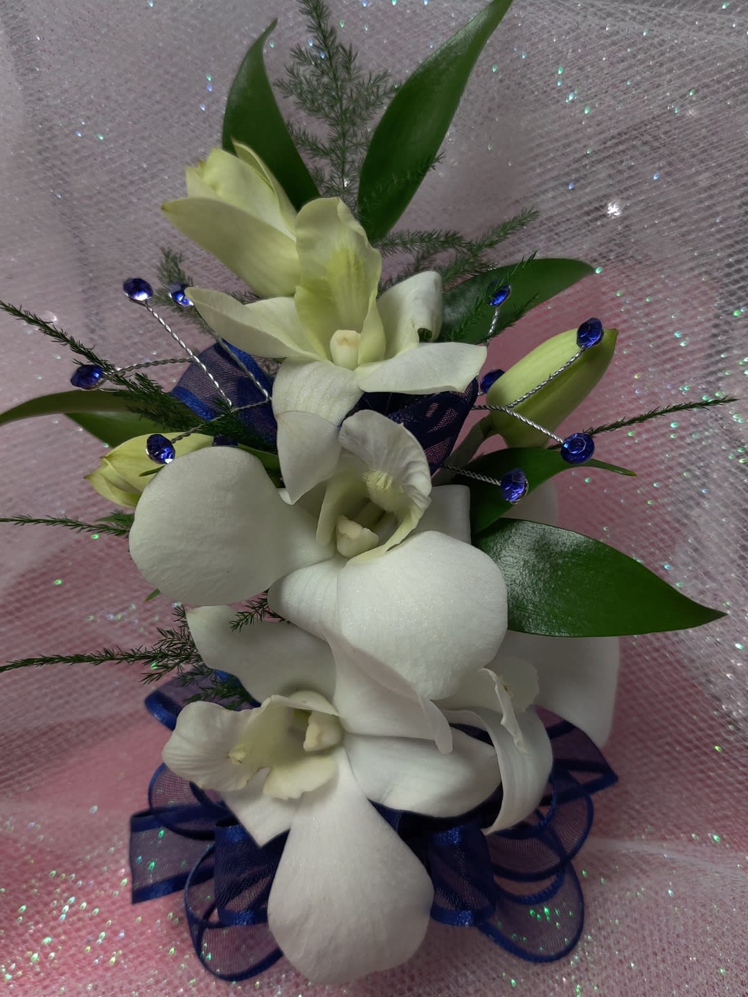 White orchid bouquet with blue ribbon and decorative beads