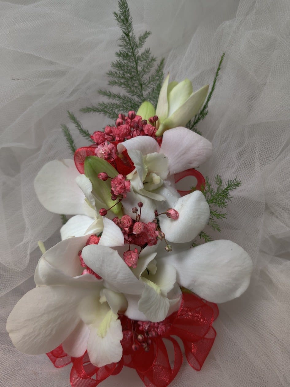 White orchid bouquet with pink accents and red ribbon