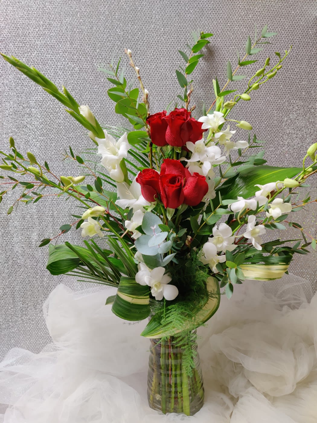 Red roses and white orchids in a glass vase