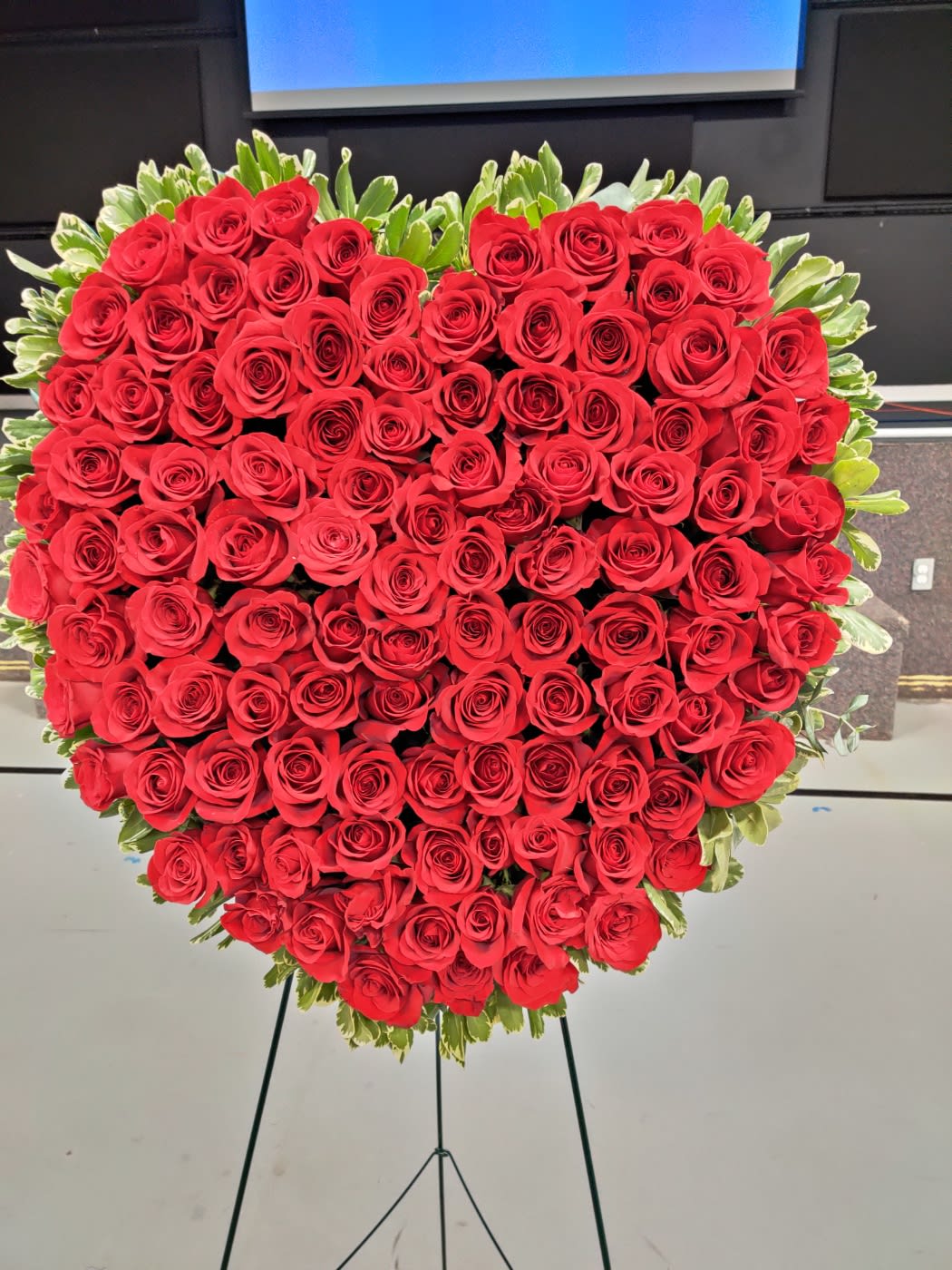 Heart-shaped arrangement of red roses on a stand