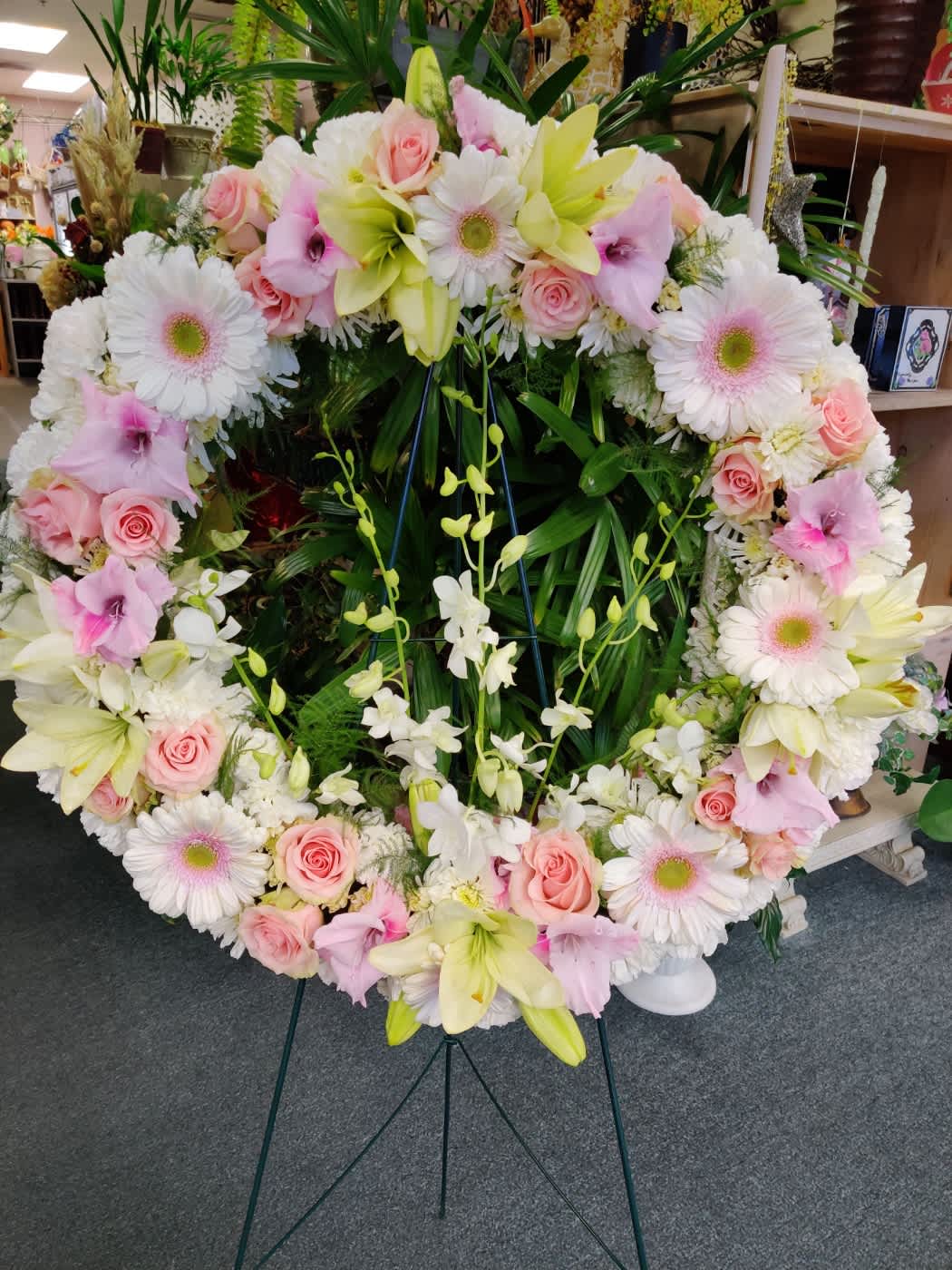 Large heart-shaped floral wreath with pink and white flowers on an easel