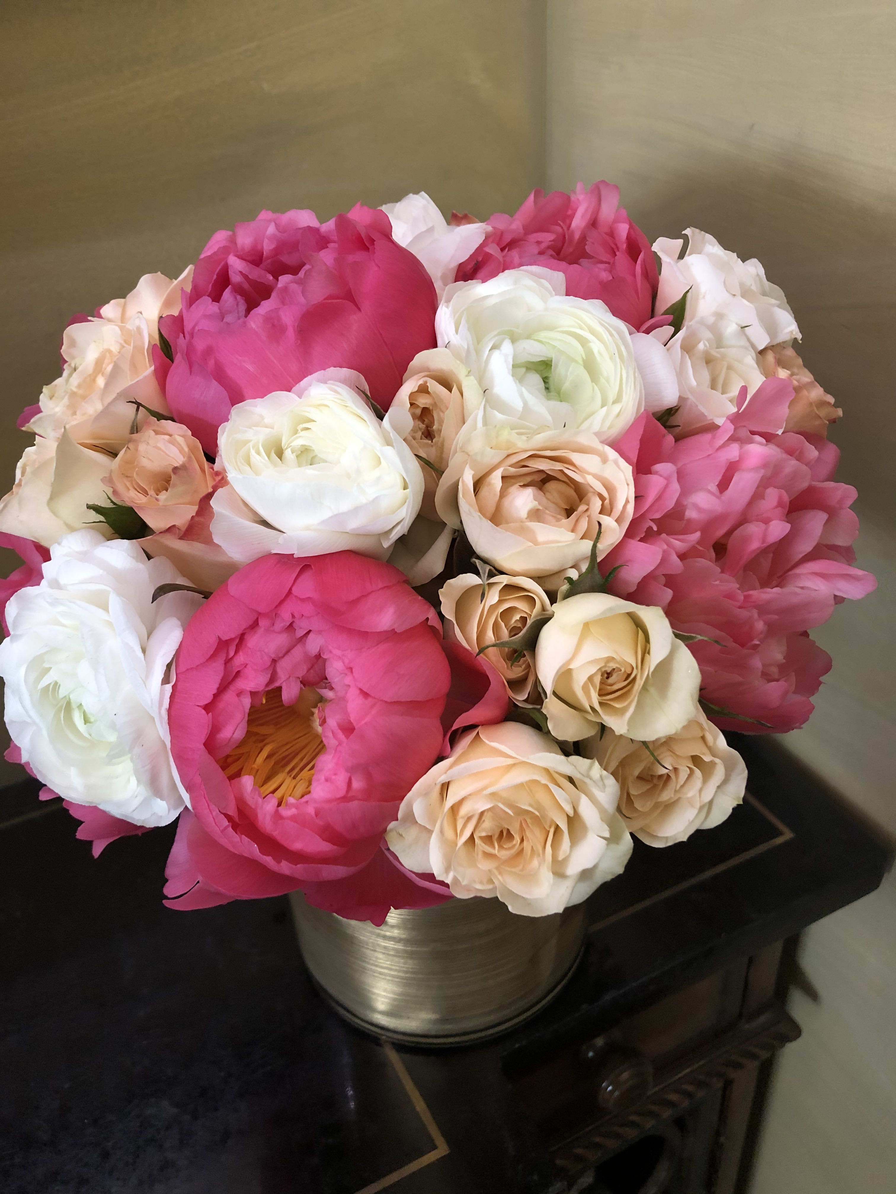 Bouquet of pink and cream peonies and roses in a metallic vase