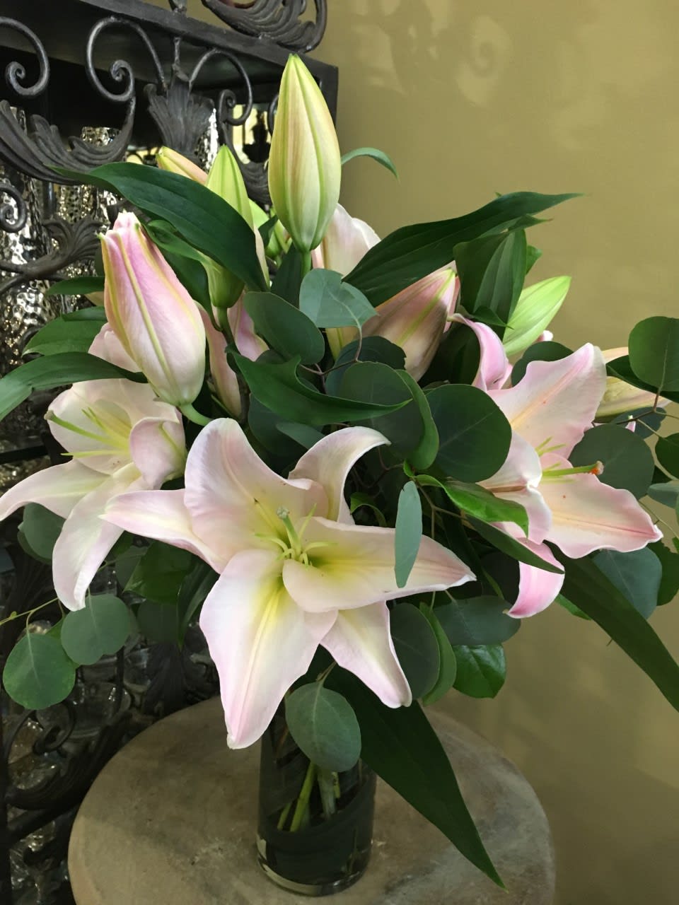 Pink and white lilies arranged in a glass vase