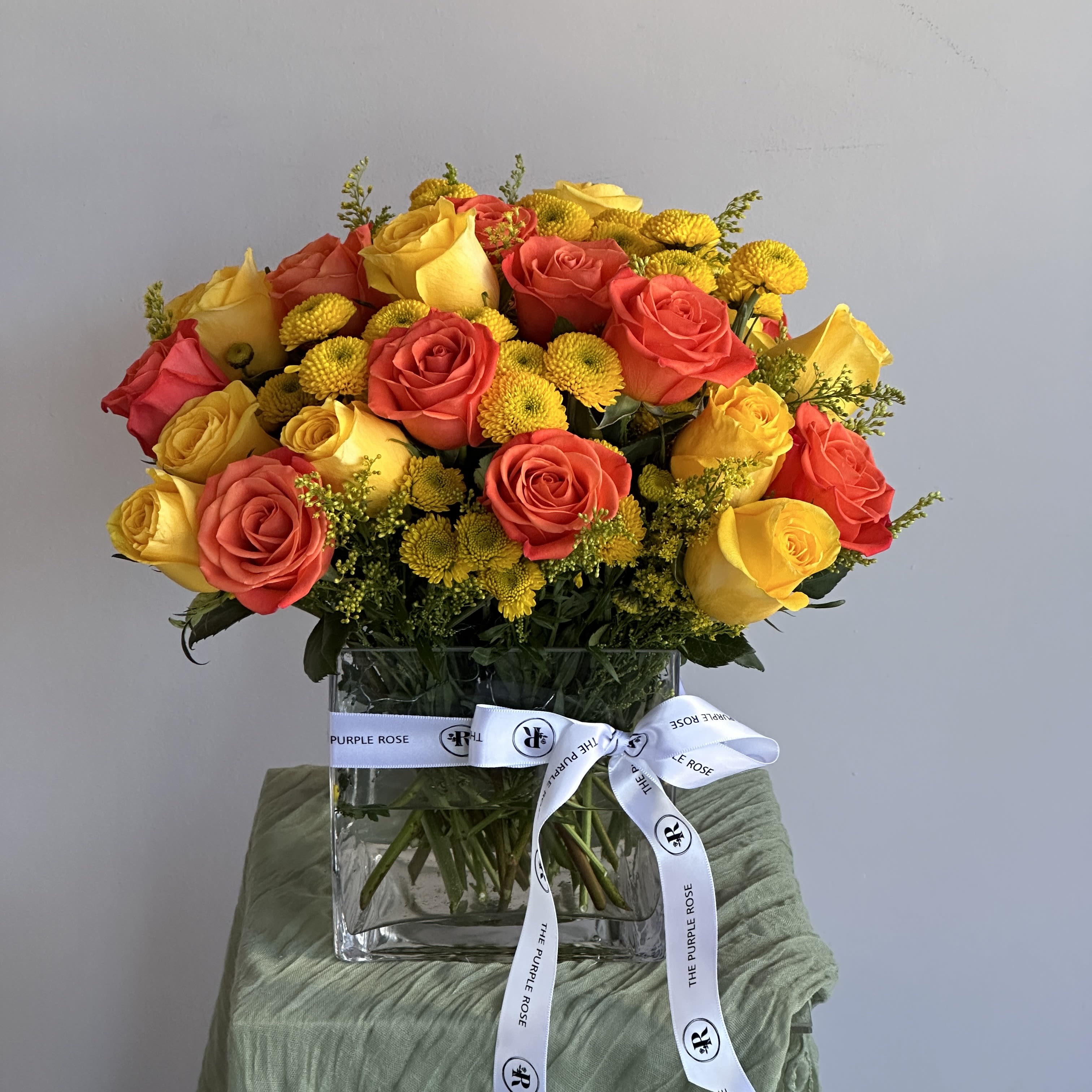 Cheer Up Buttercup D - Yellow and orange roses come together for a fun and fresh arrangement. A great arrangement to send to both men and women as a gift, these flowers light up any room. Send this for admin professionals week, Cinco De Mayo, or a birthday. PREMIUM size is shown in the picture 