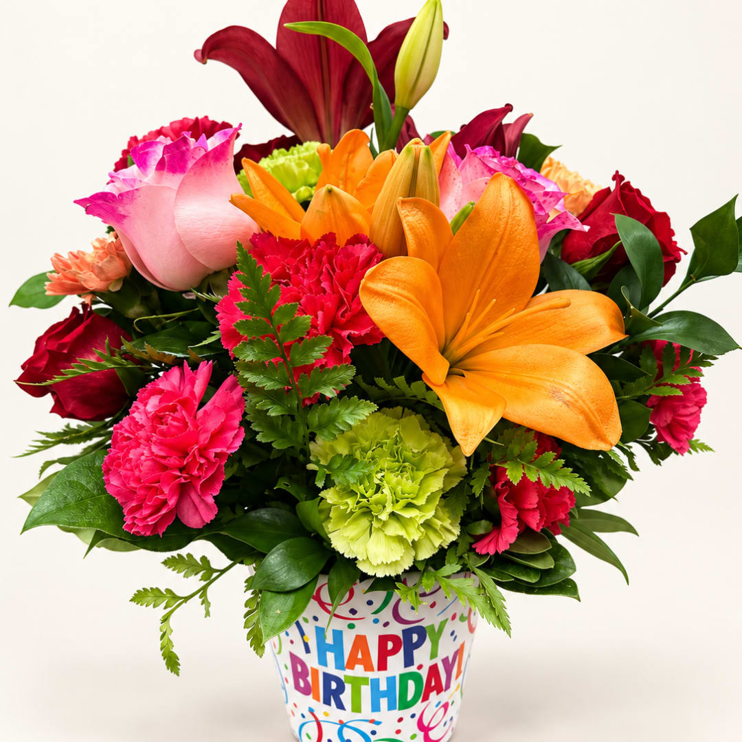 Colorful bouquet of lilies, roses, and carnations in a birthday container