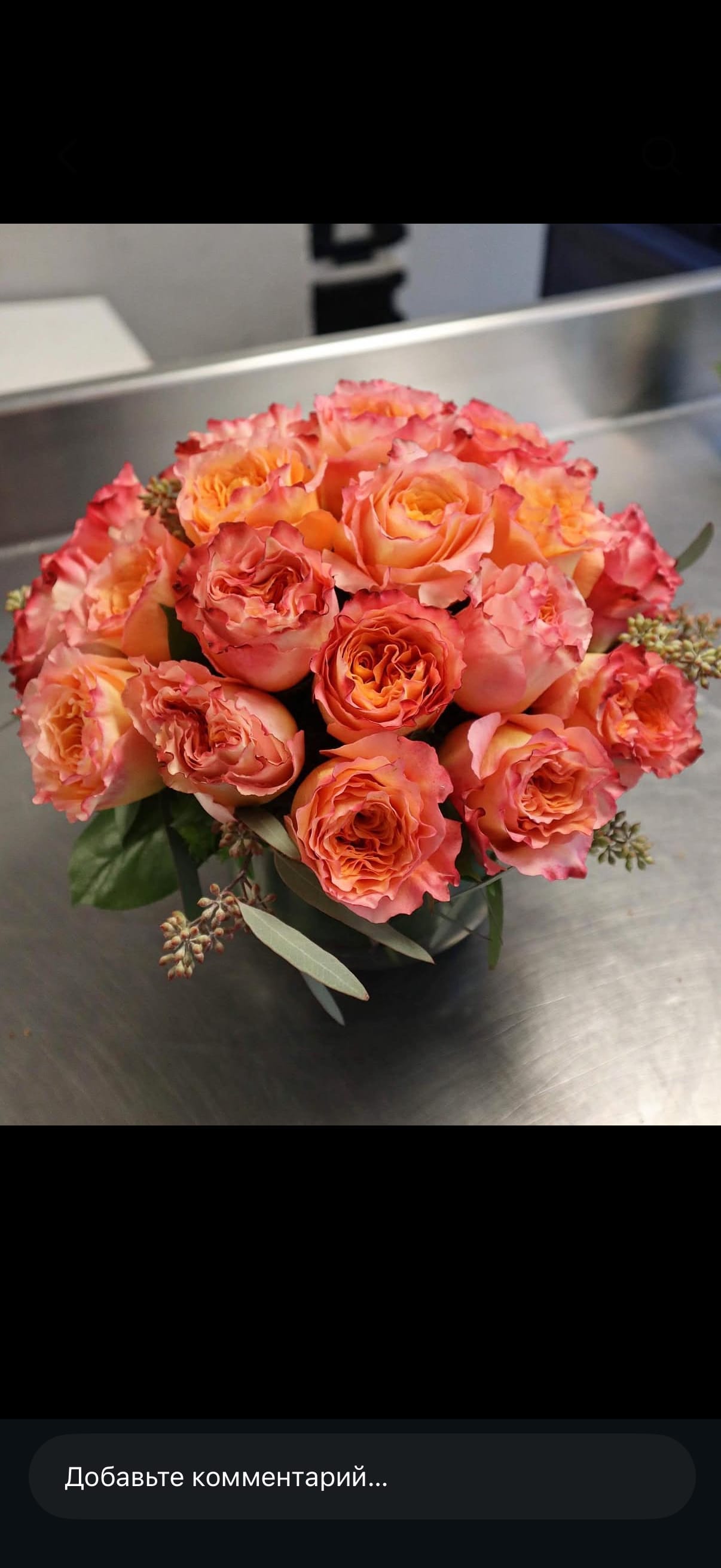 Bouquet of peach and pink roses in a dark vase