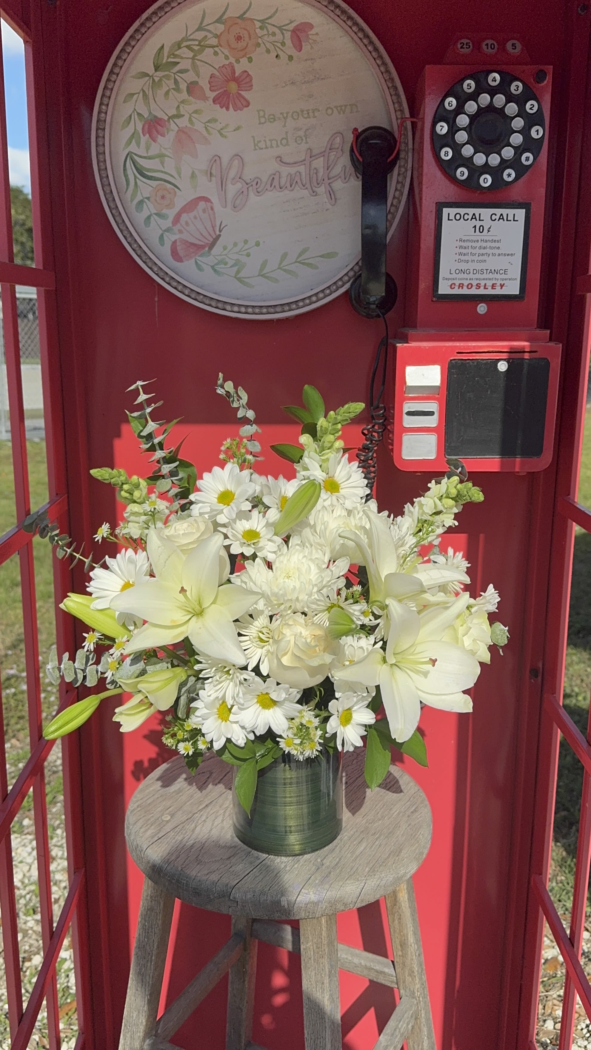 White lilies and daisies arranged in a green vase