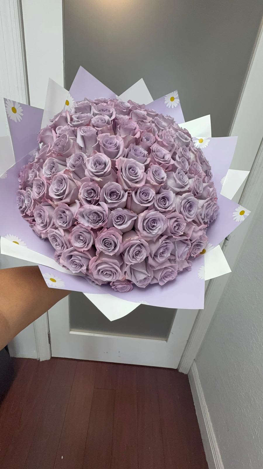 Large bouquet of lavender roses wrapped in pastel paper