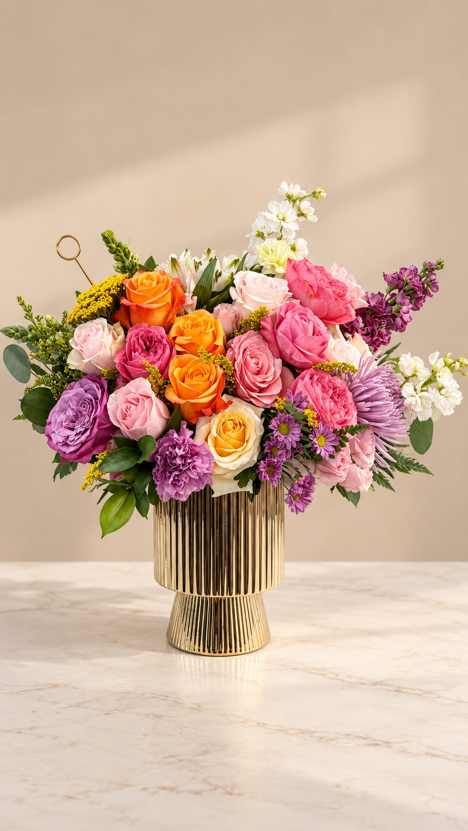 Colorful rose arrangement in a gold pedestal vase