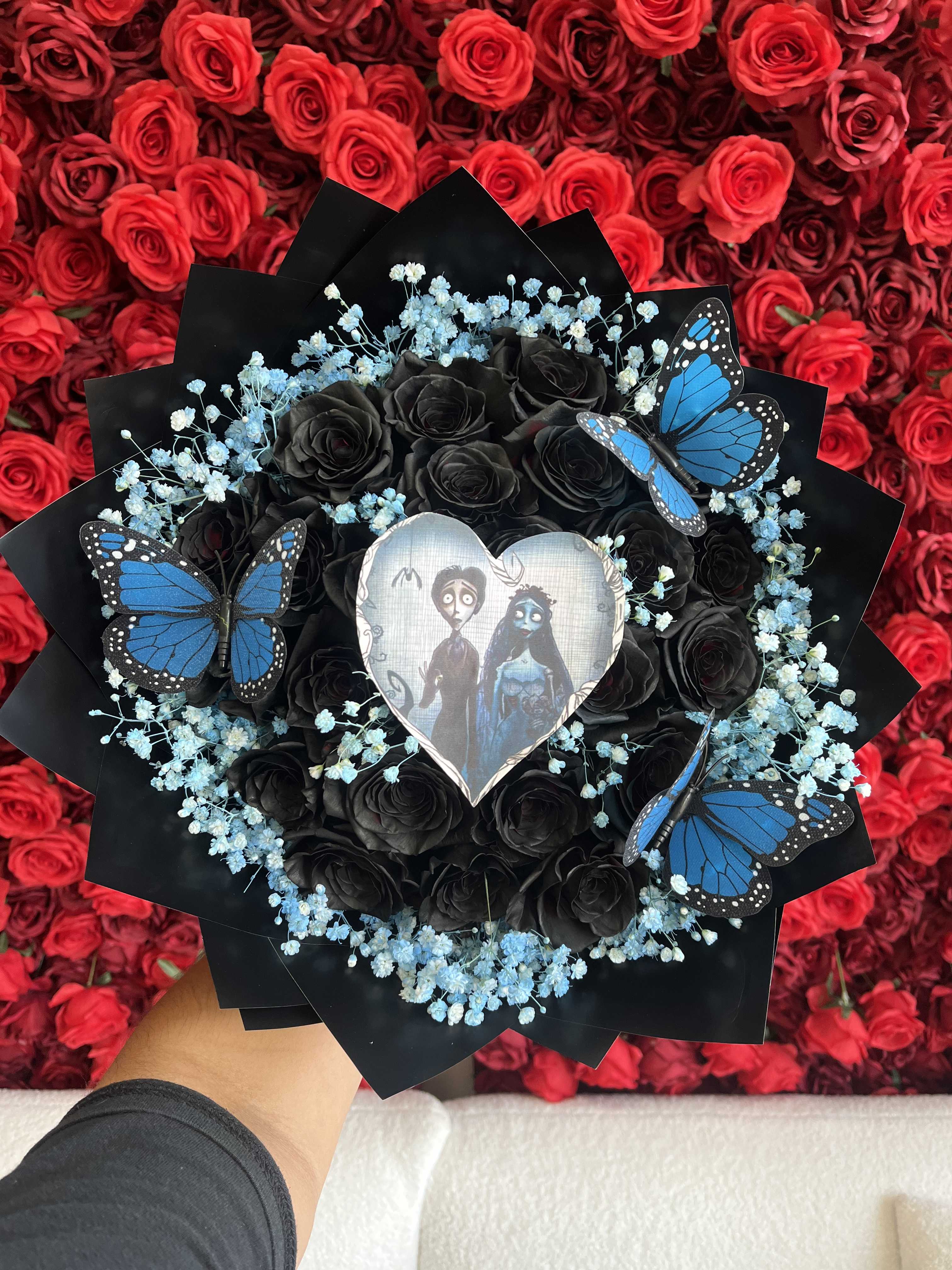 Black rose bouquet with blue baby's breath and butterfly accents