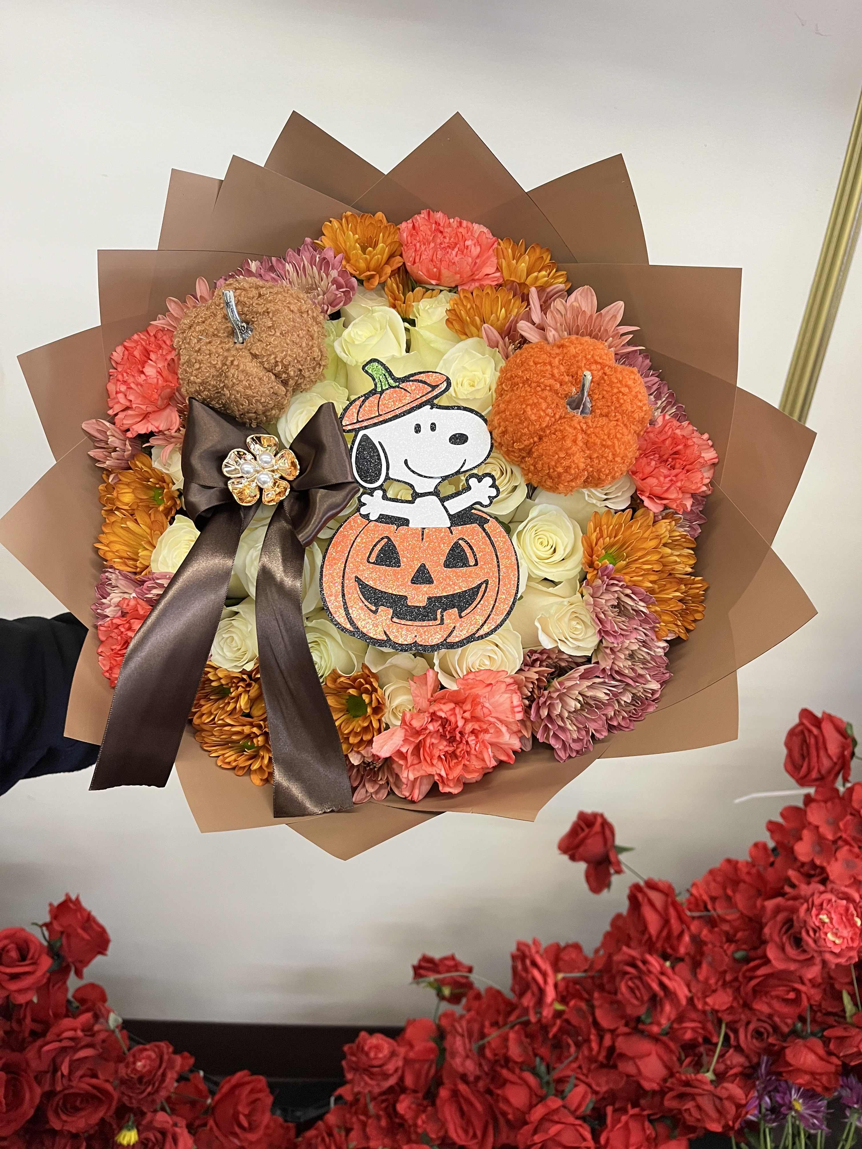 Halloween bouquet with roses, carnations, and pumpkin decorations