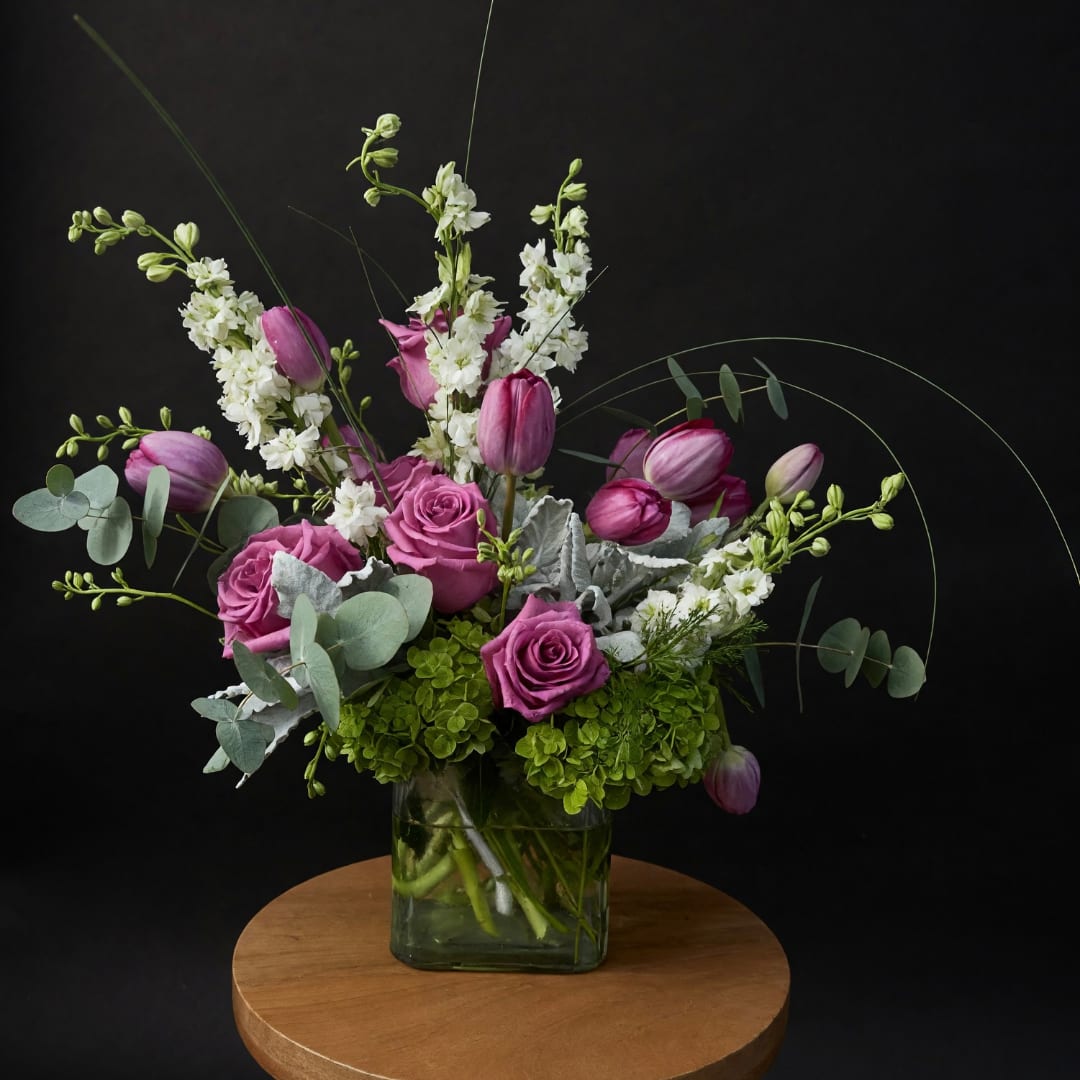 Pink roses and tulips in a glass vase with white flowers
