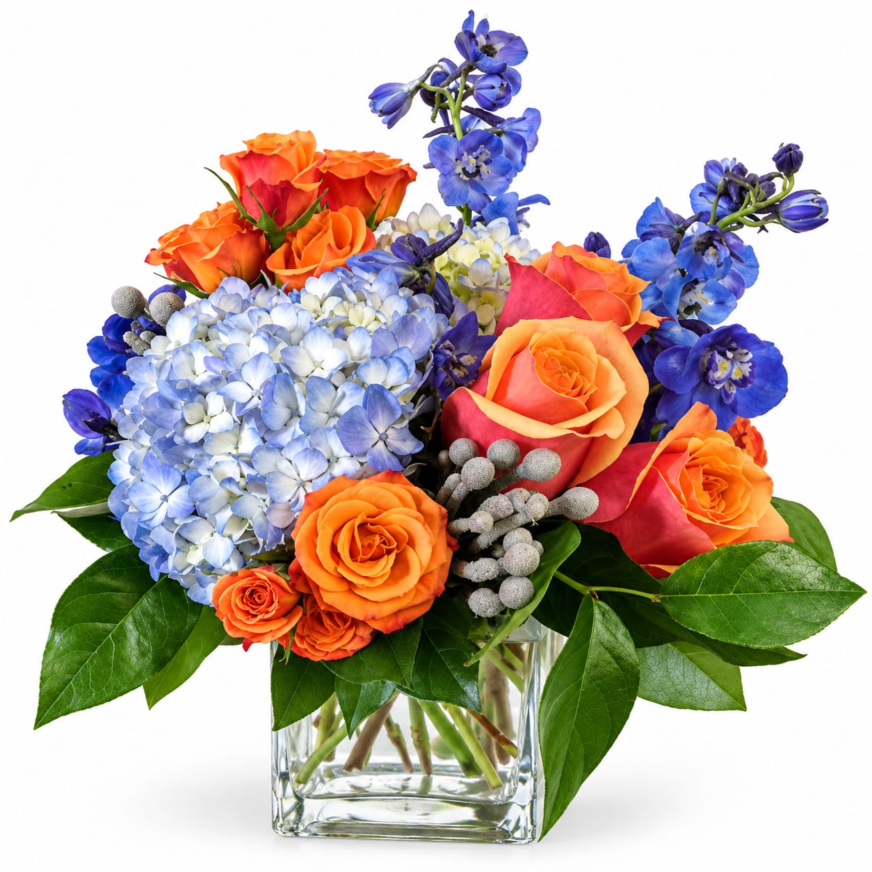 Orange roses and blue hydrangeas in a clear glass vase