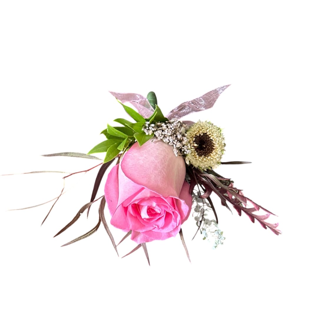 Pink rose boutonniere with small filler flowers and greenery
