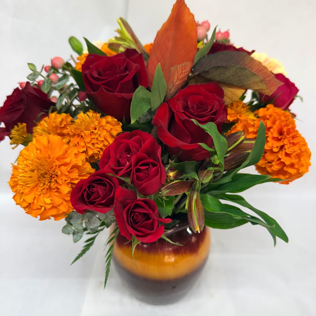 Red roses and orange marigolds arranged in a vase