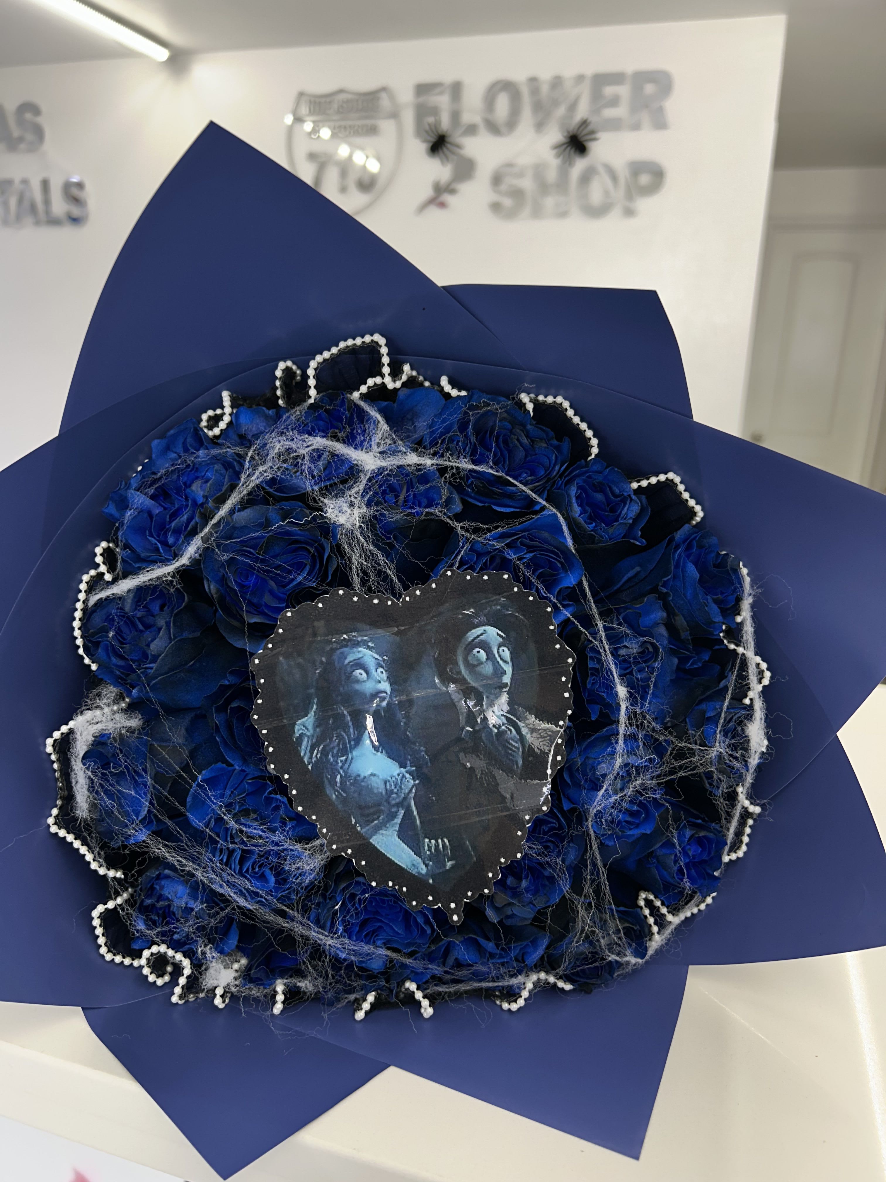 Blue rose bouquet with a decorative heart topper and pearl trim