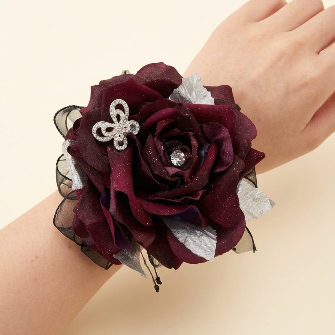 Burgundy rose wrist corsage with silver accents on a wrist