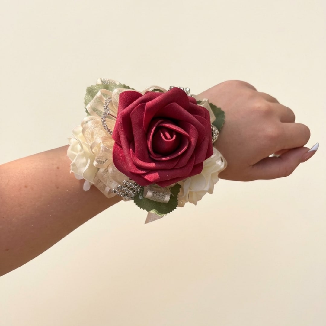 Red rose wrist corsage with cream ribbon and rhinestone accents