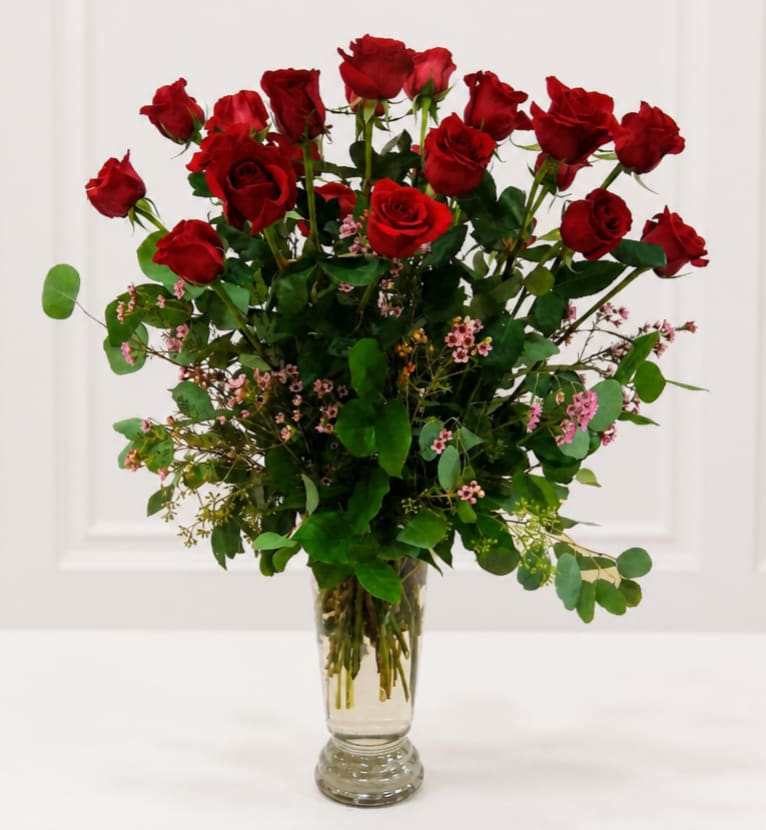 Tall bouquet of red roses in a clear glass vase