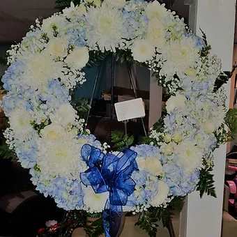 Round Floral wreath - 22 inch round wreath with roses, hydrangea, mums and lilies. Can be customized.  Please select stand and any custom gold lettering in the choices below. Requires 48 hour advance notice to prepare.