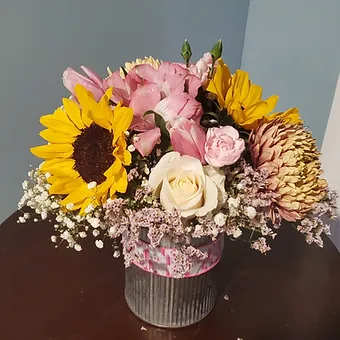 Spring splendor - Beautiful display of tulips, sunflower and white babysbreath in a galvanized tin container.